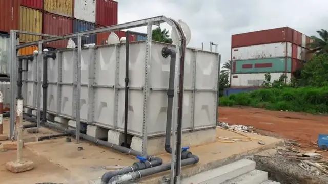 Sectional water storage tank with connected pipework