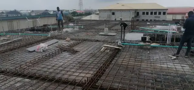Workers on a reinforced roof slab with conduit runs