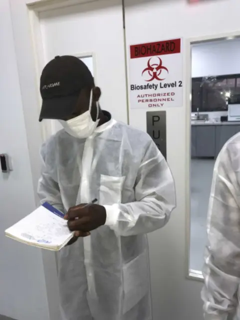 Engineer recording power readings outside a biosafety lab