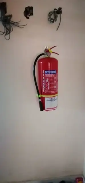 Dry powder fire extinguisher mounted on a wall