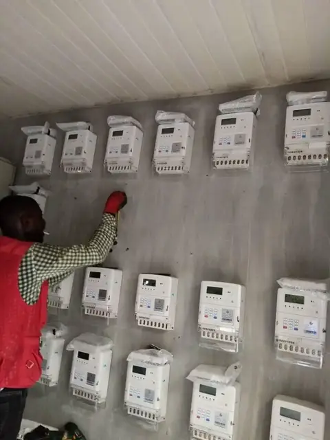 Technician installing a wall of prepaid electricity meters